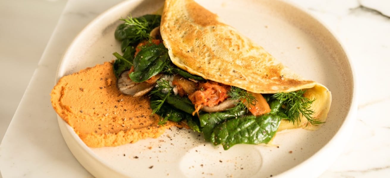 A white plate containing an omelette